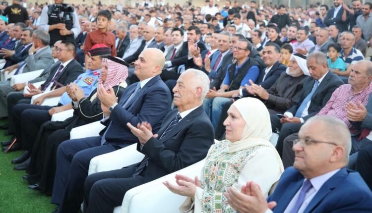 Large outdoor audience of dignitaries and attendees seated in rows, applauding at a formal ceremony.